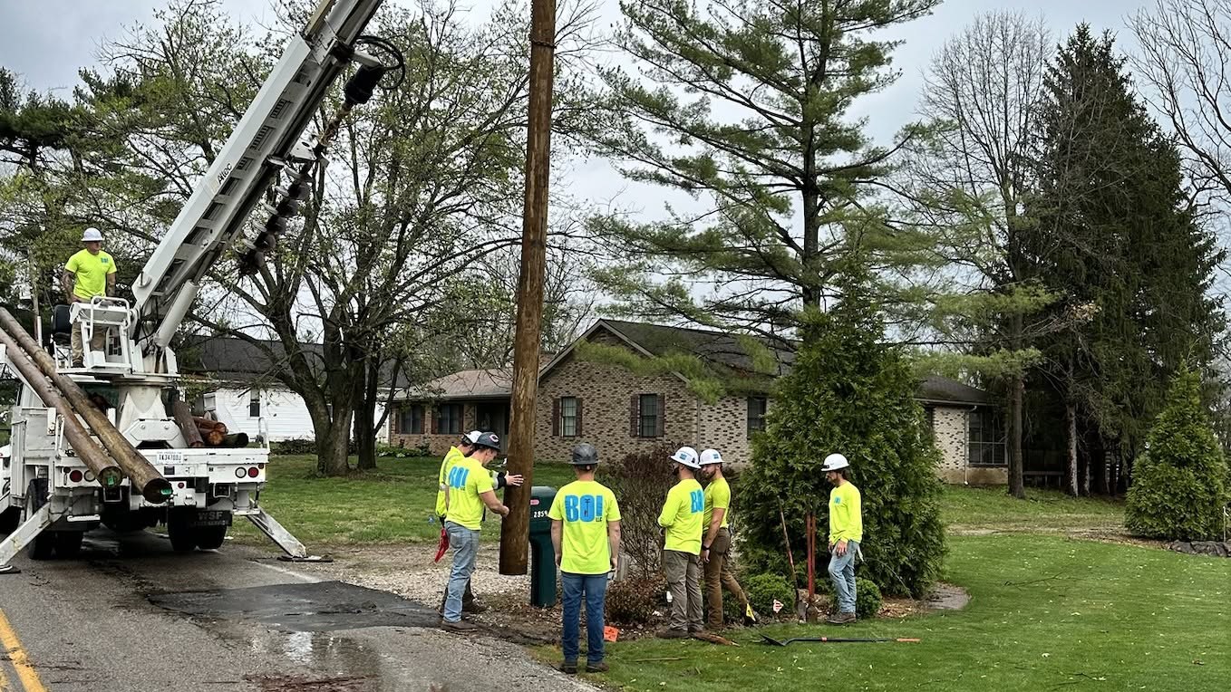 A BOI crew setting a pole in the field